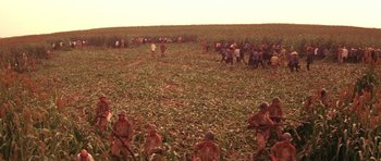 Movie still from “Red Sorghum” (1988), directed by Yimou Zhang – A group of men in a field with a bunch of horses; Extreme Wide shot, High angle