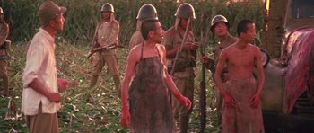Movie still from “Red Sorghum” (1988), directed by Yimou Zhang – A group of men standing next to each other in a field; Medium shot, High angle