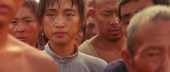 Movie still from “Red Sorghum” (1988), directed by Yimou Zhang – A group of people standing next to each other; Close Up shot, Over the shoulder angle