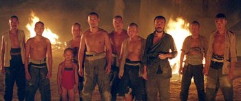 Movie still from “Red Sorghum” (1988), directed by Yimou Zhang – A group of men standing next to each other in front of a fire; Wide shot, Low angle
