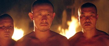 Movie still from “Red Sorghum” (1988), directed by Yimou Zhang – A shirtless man in front of a fire; Close Up shot, Low angle