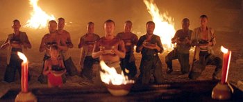 Movie still from “Red Sorghum” (1988), directed by Yimou Zhang – A group of people standing around a fire; Medium shot, High angle