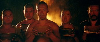 Movie still from “Red Sorghum” (1988), directed by Yimou Zhang – A group of men standing next to each other holding bowls; Medium shot, Low angle