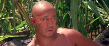 Movie still from “Red Sorghum” (1988), directed by Yimou Zhang – A man with a shaved head is looking at the camera; Close Up shot, Low angle