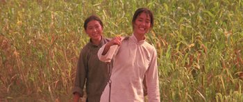 Movie still from “Red Sorghum” (1988), directed by Yimou Zhang – Two women are standing in front of a field of tall grass; Medium shot, Low angle