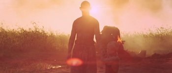 Movie still from “Red Sorghum” (1988), directed by Yimou Zhang – A man and a child are standing in a field; Medium shot, Low angle
