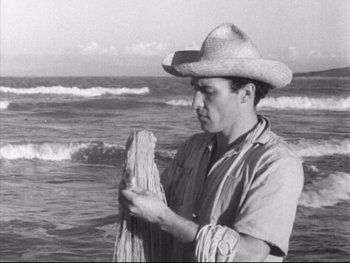 Movie still from “Redes” (1936), directed by Fred Zinnemann – A man wearing a cowboy hat standing in front of the ocean; Medium shot, Low angle