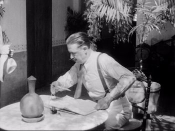 Movie still from “Redes” (1936), directed by Fred Zinnemann – An old photo of a man at a table cutting a cake; Medium shot, High angle