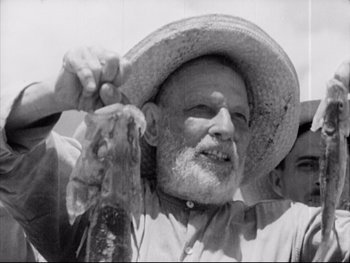 Movie still from “Redes” (1936), directed by Fred Zinnemann – An old man wearing a straw hat holding a fish; Close Up shot, Low angle
