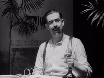 Movie still from “Redes” (1936), directed by Fred Zinnemann – A black and white photo of a man holding a drink; Close Up shot, Low angle
