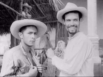 Movie still from “Redes” (1936), directed by Fred Zinnemann – Two men wearing hats and smiling for the camera; Medium shot, Low angle