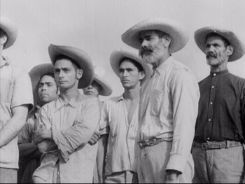 Movie still from “Redes” (1936), directed by Fred Zinnemann – A black and white photo of a group of men wearing hats; Medium shot, Low angle