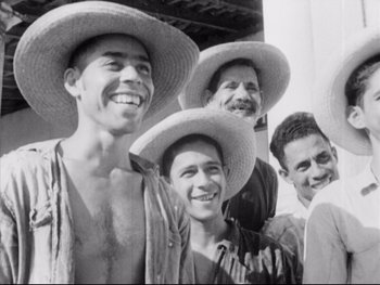 Movie still from “Redes” (1936), directed by Fred Zinnemann – A black and white photo of a group of men wearing hats; Medium shot, High angle