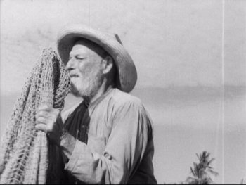 Movie still from “Redes” (1936), directed by Fred Zinnemann – An old man wearing a cowboy hat holding a basket; Medium shot, Low angle