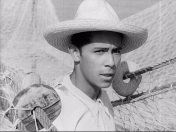 Movie still from “Redes” (1936), directed by Fred Zinnemann – A man wearing a straw hat and holding a baseball bat; Close Up shot, Low angle