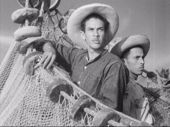 Movie still from “Redes” (1936), directed by Fred Zinnemann – Two men wearing hats are standing next to a fishing net; Medium shot, Low angle