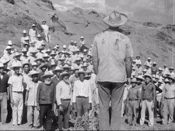 Movie still from “Redes” (1936), directed by Fred Zinnemann – A group of men standing in front of each other in a field; Wide shot, Low angle