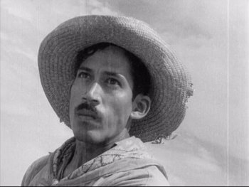 Movie still from “Redes” (1936), directed by Fred Zinnemann – A man wearing a straw hat and a scarf; Close Up shot, Low angle