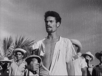 Movie still from “Redes” (1936), directed by Fred Zinnemann – Black and white photograph of a man in a white shirt holding a whip; Medium shot, Low angle