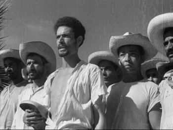 Movie still from “Redes” (1936), directed by Fred Zinnemann – A black and white photo of a group of men wearing hats; Medium shot, Low angle
