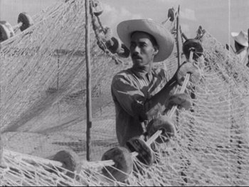Movie still from “Redes” (1936), directed by Fred Zinnemann – A man in a cowboy hat holding a pole; Medium shot, Low angle