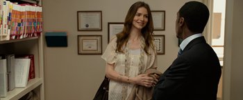 Movie still from “Reign Over Me” (2007), directed by Mike Binder – A woman standing in front of a wall holding a cell phone; Medium shot, Over the shoulder angle