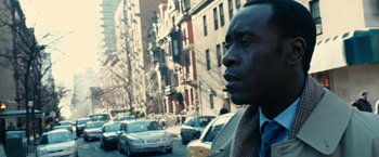 Movie still from “Reign Over Me” (2007), directed by Mike Binder – A man in a suit and tie standing in front of a busy city street; Close Up shot, Over the shoulder angle