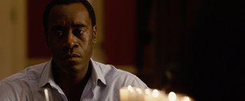 Movie still from “Reign Over Me” (2007), directed by Mike Binder – A man sitting in front of a lit candle in a room; Close Up shot, Over the shoulder angle