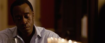 Movie still from “Reign Over Me” (2007), directed by Mike Binder – A man sitting in front of a table with lit candles; Close Up shot, Over the shoulder angle