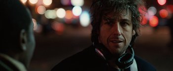 Movie still from “Reign Over Me” (2007), directed by Mike Binder – A person wearing headphones near a street; Close Up shot, Over the shoulder angle
