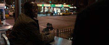 Movie still from “Reign Over Me” (2007), directed by Mike Binder – A man sitting at a table in front of a city street; Close Up shot, Over the shoulder angle