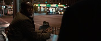 Movie still from “Reign Over Me” (2007), directed by Mike Binder – A man sitting at a table in front of a building; Medium shot, Over the shoulder angle