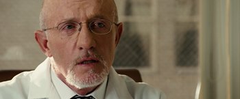 Movie still from “Reign Over Me” (2007), directed by Mike Binder – An older man wearing glasses and a white coat; Close Up shot, Low angle