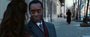 Movie still from “Reign Over Me” (2007), directed by Mike Binder – A man wearing a suit and tie standing on a sidewalk; Close Up shot, Over the shoulder angle