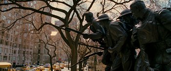 Movie still from “Reign Over Me” (2007), directed by Mike Binder – A statue of a man holding a rifle next to a tree; Wide shot, Low angle