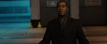 Movie still from “Reign Over Me” (2007), directed by Mike Binder – A man wearing a suit and tie standing in front of a building; Medium shot, Over the shoulder angle