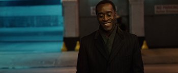Movie still from “Reign Over Me” (2007), directed by Mike Binder – A man in a black jacket smiling for the camera; Close Up shot, Over the shoulder angle