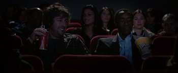 Movie still from “Reign Over Me” (2007), directed by Mike Binder – A group of people sitting in a movie theater; Medium shot, Over the shoulder angle