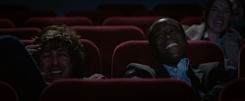 Movie still from “Reign Over Me” (2007), directed by Mike Binder – A man and a woman are sitting in a movie theater; Medium shot, Low angle