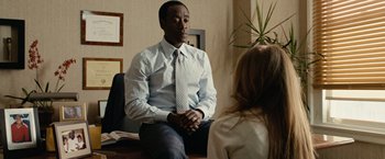 Movie still from “Reign Over Me” (2007), directed by Mike Binder – A man and a woman sitting in front of each other in a room; Medium shot, Over the shoulder angle