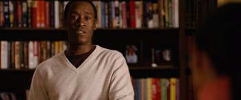 Movie still from “Reign Over Me” (2007), directed by Mike Binder – A man sitting in front of a book shelf in a room; Close Up shot, Over the shoulder angle