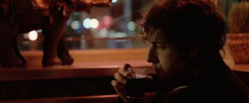 Movie still from “Reign Over Me” (2007), directed by Mike Binder – A man drinking a cup of coffee while sitting at a table; Close Up shot, Over the shoulder angle