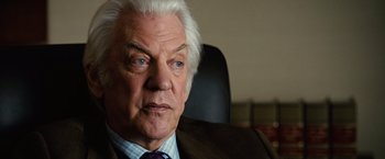 Movie still from “Reign Over Me” (2007), directed by Mike Binder – An older man sitting in an office chair; Close Up shot, Over the shoulder angle