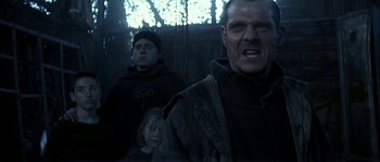 Movie still from “Reign of Fire” (2002), directed by Rob Bowman – A man and a child in a dark room; Close Up shot, Low angle