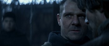 Movie still from “Reign of Fire” (2002), directed by Rob Bowman – A person wearing a jacket and looking at the camera; Close Up shot, Over the shoulder angle