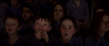 Movie still from “Reign of Fire” (2002), directed by Rob Bowman – A group of kids watching something in the dark; Close Up shot, High angle