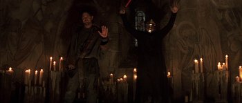 Movie still from “Reign of Fire” (2002), directed by Rob Bowman – A man and a woman dressed in costume in a dark room; Medium shot, Low angle