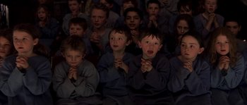 Movie still from “Reign of Fire” (2002), directed by Rob Bowman – A group of young boys sitting in a room; Medium shot, High angle