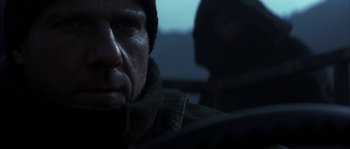 Movie still from “Reign of Fire” (2002), directed by Rob Bowman – A person wearing a jacket and a hat; Close Up shot, Over the shoulder angle