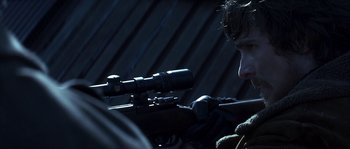 Movie still from “Reign of Fire” (2002), directed by Rob Bowman – A man is holding a rifle and looking through a scope; Close Up shot, Over the shoulder angle